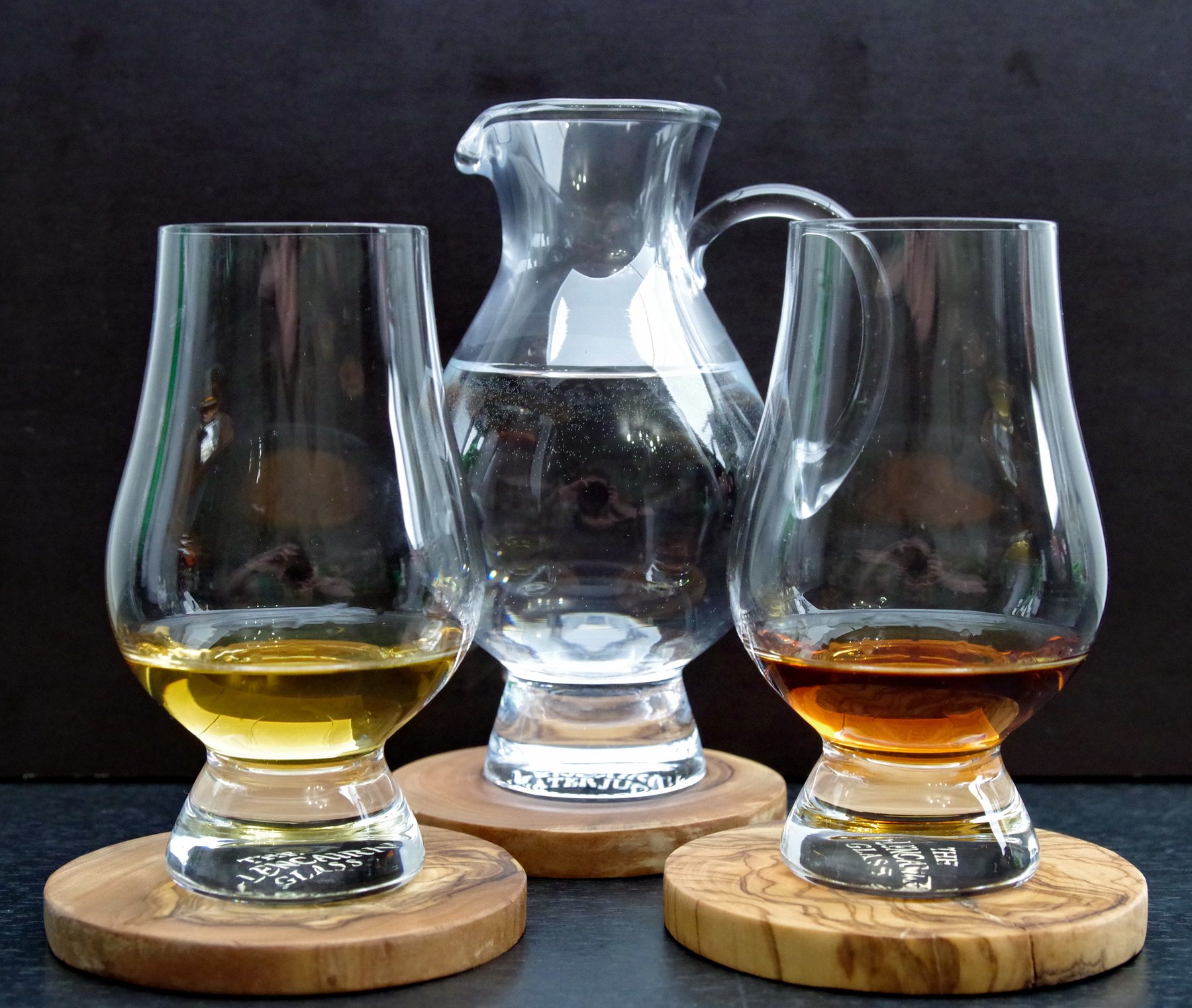 Два бокала Glencairn для нозинга с виски — светлым и тёмным — и графин с водой между ними, дегустационный ряд